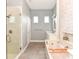 Bright bathroom featuring a soaking tub with accent wall and a glass shower at 1357 Liam Cir, Ormond Beach, FL 32174