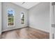 An empty bedroom with hardwood floors, neutral walls, and abundant natural light from arched windows at 1357 Liam Cir, Ormond Beach, FL 32174