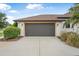Close-up view of the two-car garage with a gray door, exterior lighting, and clean concrete driveway at 1357 Liam Cir, Ormond Beach, FL 32174