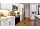 Modern kitchen showcasing white cabinets, stainless steel appliances, marble counters, and hardwood flooring at 1357 Liam Cir, Ormond Beach, FL 32174