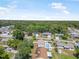 Aerial view of homes with a pool, mature trees and green lawns under a sunny sky at 2 Wildwood Dr, Edgewater, FL 32132