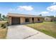 Charming brick home featuring an attached garage and a concrete driveway at 2 Wildwood Dr, Edgewater, FL 32132