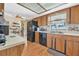View of the kitchen featuring tile backsplash, black appliances and wood cabinets at 2 Wildwood Dr, Edgewater, FL 32132