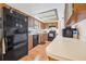 View of the kitchen featuring tile backsplash, black appliances and wood cabinets at 2 Wildwood Dr, Edgewater, FL 32132