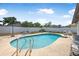 Sparkling in-ground pool surrounded by a concrete deck and a white fence at 2 Wildwood Dr, Edgewater, FL 32132