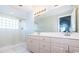 Bright bathroom featuring a double vanity, a large mirror, and a glass enclosed shower with tiled walls at 3074 Ocean Shore Blvd, Ormond Beach, FL 32176