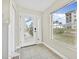 Bright entryway featuring tile flooring, a large window, and a white front door with glass panels at 3074 Ocean Shore Blvd, Ormond Beach, FL 32176