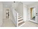 Foyer with tile flooring, stairs, and a view into the kitchen with white cabinets at 3074 Ocean Shore Blvd, Ormond Beach, FL 32176