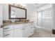 Bathroom boasts a granite countertop vanity, decorative mirror, and tiled shower at 3076 Ocean Shore Blvd, Ormond Beach, FL 32176