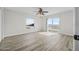 Bedroom with wood-look flooring, ceiling fan, and balcony access offering serene views at 3076 Ocean Shore Blvd, Ormond Beach, FL 32176