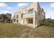 Back exterior view of home with tan stucco, white railing and green yard at 3076 Ocean Shore Blvd, Ormond Beach, FL 32176