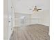 A loft area features wood-look flooring, a ceiling fan, and a railing overlooking a balcony at 3076 Ocean Shore Blvd, Ormond Beach, FL 32176