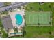 Aerial view of a pool and tennis court area surrounded by lush landscaping and green space at 3370 Ocean Shore Blvd # 205-B, Ormond Beach, FL 32176