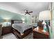 Cozy bedroom with wood-look floors, soothing green walls, and ceiling fan at 3370 Ocean Shore Blvd # 205-B, Ormond Beach, FL 32176