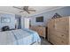 Bedroom with wood floors, ceiling fan, light blue walls and dressers for storage at 3370 Ocean Shore Blvd # 205-B, Ormond Beach, FL 32176