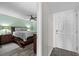 View into bedroom with wood-look floors, soothing green walls, and ceiling fan at 3370 Ocean Shore Blvd # 205-B, Ormond Beach, FL 32176
