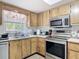 Functional kitchen with wood cabinets, stainless steel appliances, and a bright window above the sink at 420 Banana Cay Dr # A, South Daytona, FL 32119