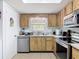 Well-lit kitchen featuring wood cabinets and stainless steel appliances at 420 Banana Cay Dr # A, South Daytona, FL 32119
