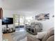 Comfortable living room with tile flooring, sliding glass doors to the outside, and coastal artwork at 420 Banana Cay Dr # A, South Daytona, FL 32119