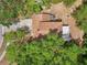 Aerial view of a home showcasing its roof, driveway, and outdoor space with mature trees and a fire pit at 440 Champagne Cir, Port Orange, FL 32127
