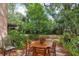 A backyard patio area is furnished with a round wooden table and four chairs at 440 Champagne Cir, Port Orange, FL 32127