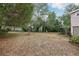Large backyard with mature trees and view of screened in patio, offering ample space at 440 Champagne Cir, Port Orange, FL 32127