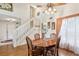 Bright dining room features wood floors, a ceiling fan and stairs leading to the second level at 440 Champagne Cir, Port Orange, FL 32127