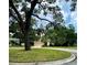 View of a two-story home with a two-car garage, framed by trees with Spanish moss at 440 Champagne Cir, Port Orange, FL 32127
