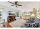 Spacious living room with hardwood floors, a large TV, and access to outdoor patio at 440 Champagne Cir, Port Orange, FL 32127