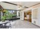 Enclosed patio featuring tile flooring, ceiling fan, outdoor grill, and entrance to the kitchen at 440 Champagne Cir, Port Orange, FL 32127
