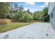 Home backyard featuring a patio and privacy fence, surrounded by lush greenery at 5620 Ridgewood Ave, De Leon Springs, FL 32130
