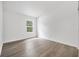 Bright room with wood-look floors, white trim, and a single window, creating a cozy and inviting space at 5620 Ridgewood Ave, De Leon Springs, FL 32130