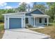 Charming single-story home featuring a front-facing garage and covered porch at 5620 Ridgewood Ave, De Leon Springs, FL 32130