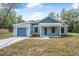 Charming single-story home featuring a front-facing garage and covered porch at 5620 Ridgewood Ave, De Leon Springs, FL 32130