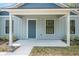 Close up of the front porch of a single-story home with a blue front door at 5620 Ridgewood Ave, De Leon Springs, FL 32130