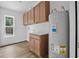 Bright laundry room features wooden cabinets, light countertops, and a window bringing in natural light at 5620 Ridgewood Ave, De Leon Springs, FL 32130