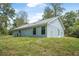 Home exterior with green lawn and side entry at 5620 Ridgewood Ave, De Leon Springs, FL 32130