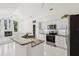 Modern kitchen with stainless steel appliances, granite countertops, and a breakfast bar overlooking a cozy fireplace at 6 Talaquah Blvd, Ormond Beach, FL 32174