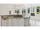 Bright kitchen with granite counters, white cabinets, and stainless steel appliances opens to a pool view at 6 Talaquah Blvd, Ormond Beach, FL 32174