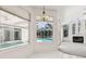 Bright living room with pool view featuring a modern fireplace and plenty of natural light at 6 Talaquah Blvd, Ormond Beach, FL 32174