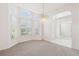 Bright living room featuring a chandelier, large windows with shutter shades and neutral carpet at 6 Talaquah Blvd, Ormond Beach, FL 32174