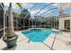 Inviting screened-in pool with clear blue water, surrounded by lush greenery and a relaxing spa area at 6 Talaquah Blvd, Ormond Beach, FL 32174