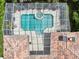 Aerial view of a screened-in pool and spa area, complemented by a well-maintained tile roof and surrounding foliage at 6 Talaquah Blvd, Ormond Beach, FL 32174