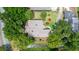 Bird's eye view of house with nice roof surrounded by mature trees and a small creek or drainage ditch at 912 Fruitwood Pl, Port Orange, FL 32127