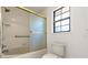 Bathroom with tiled shower, glass doors, and grab bar at 912 Fruitwood Pl, Port Orange, FL 32127