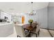 Elegant dining room with modern chandelier, wood table, comfortable seating, and access to the kitchen at 912 Fruitwood Pl, Port Orange, FL 32127