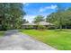 Charming single-story brick home with a long driveway, a well-manicured lawn, and mature trees at 912 Fruitwood Pl, Port Orange, FL 32127