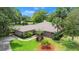 Charming single-story brick home with a well-manicured lawn, mature trees and a two car garage at 912 Fruitwood Pl, Port Orange, FL 32127