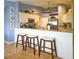 Modern kitchen with breakfast bar, pendant lighting, and decorative accents, and a stainless steel refrigerator at 10031 Sw 62Nd Cir, Ocala, FL 34476