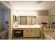 Bright bathroom featuring a spacious vanity, large mirror, and a bathtub for relaxation at 10031 Sw 62Nd Cir, Ocala, FL 34476